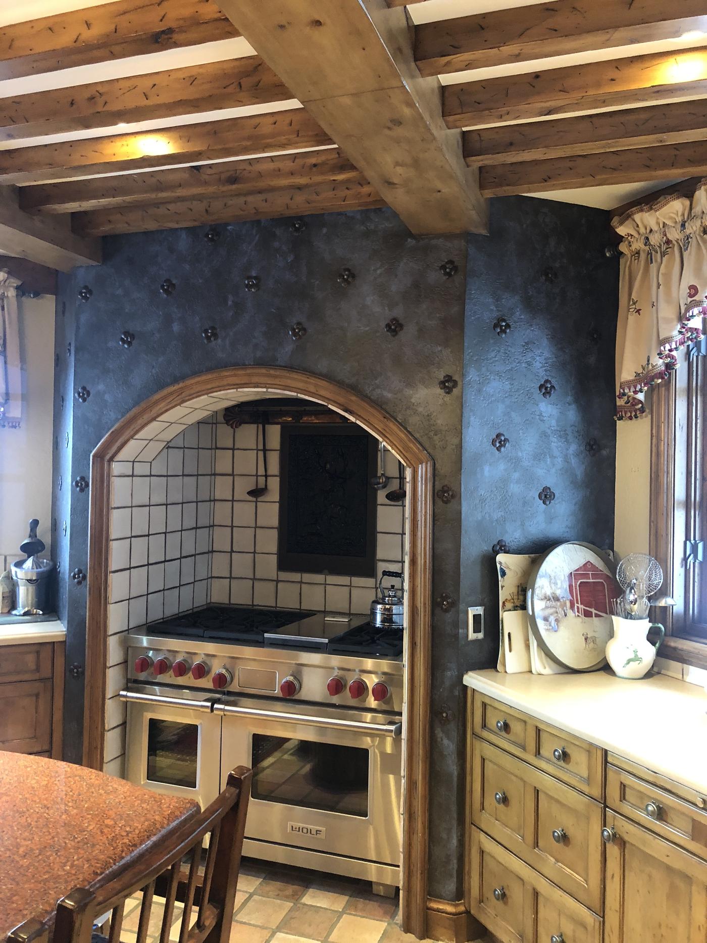 Custom blue kitchen cabinetry with hand-applied finish