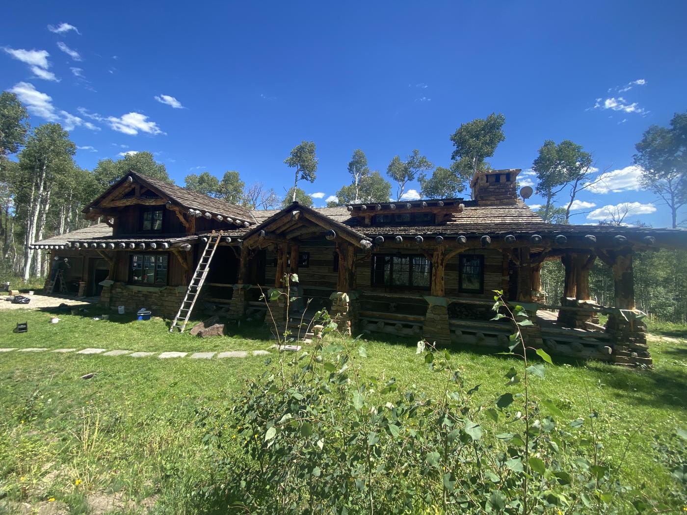 Timber lodge home being stained among the aspens