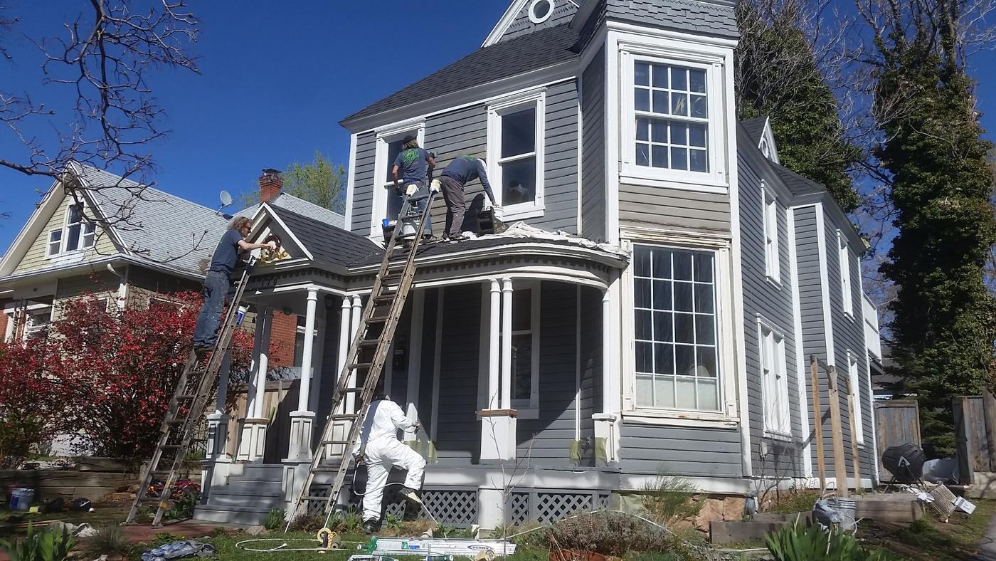 Crew repainting a Victorian home on ladders